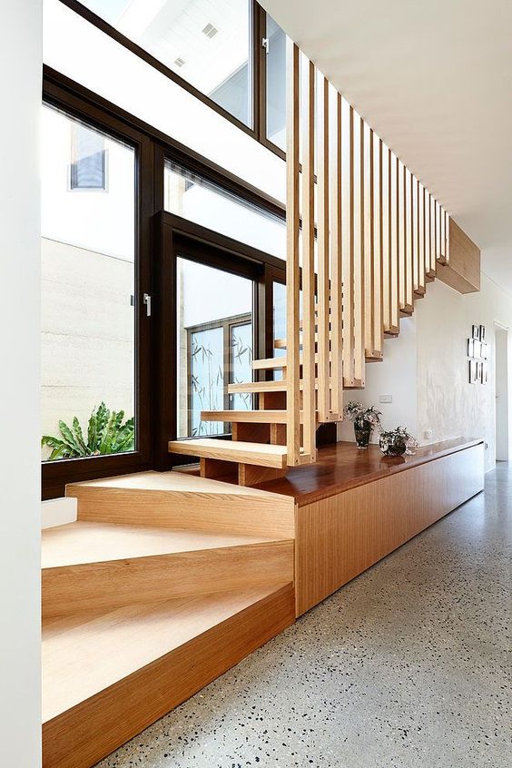 Scara din lemn facuta din doua parti primele trepte balansate cu suport cu depozitare si restul scarii cu vang central si trepte din lemn cu riflaj vertical despartitor